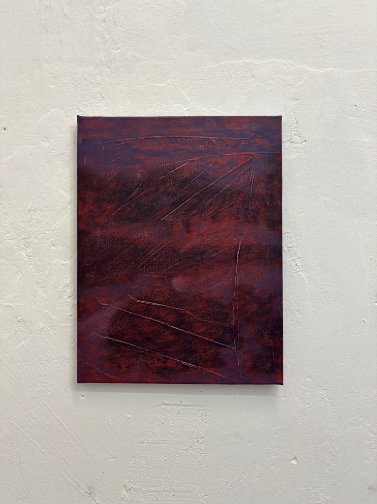 Picture of a dark purple and red landscape painting with textured markings hanging on a white, gallery wall.
